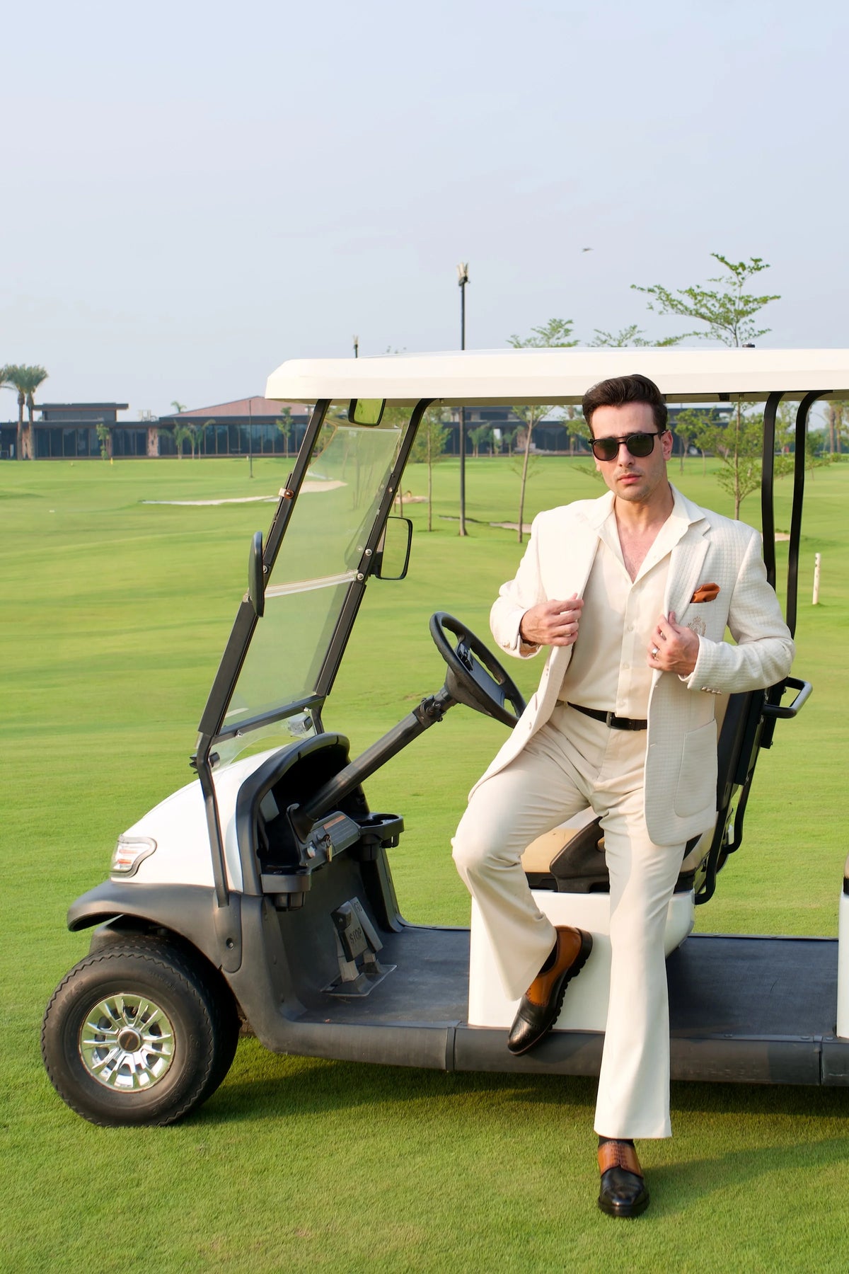 A client in a cream suit and Cueřo shoes stepping out of a golf cart