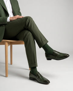 Best Carlton olive leather loafers styled with formal outfit in seated editorial pose highlighting comfort, craftsmanship, and refined luxury