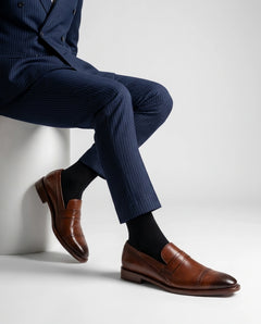 Carpio brogue leather loafer styled with formal outfit in seated lifestyle pose showcasing comfort and modern luxury menswear style