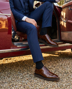 The Beaumont Cueřo Grand Atelier luxury men’s brown formal dress shoes styled in a luxury car lifestyle scene, showcasing polished leather finish and elegant formal wear aesthetic