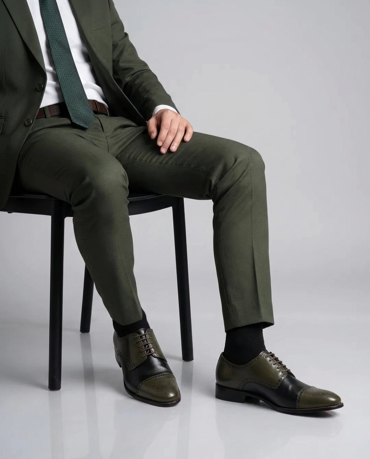 Ducaro wingtip lace-up shoes styled with formal outfit in sitting editorial pose highlighting handmade luxury and refined style