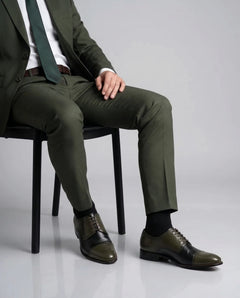Ducaro wingtip lace-up shoes styled with formal outfit in sitting editorial pose highlighting handmade luxury and refined style