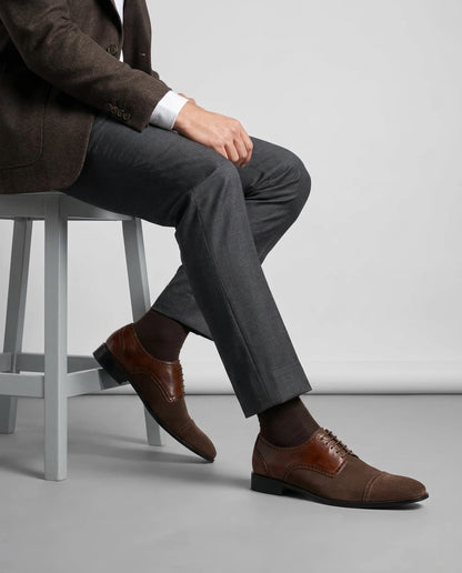 Lifestyle shot of Duke’s Plush lace-up oxford shoes worn with tailored menswear, seated pose showcasing elegant formal styling and premium finish