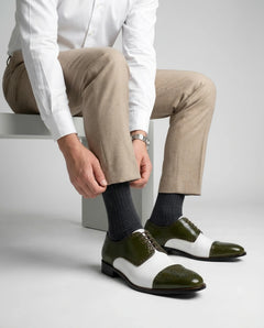 Ebony and Ivory brogue shoes styled with formal outfit in sitting lifestyle shot showcasing bold menswear fashion
