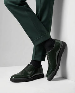 Close-up of Elroy green glossy lace-up shoes showing premium patent leather finish, fine stitching, and high shine surface with luxury craftsmanship detail