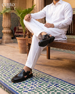 Man sitting on a bench black-woven-peshawari-chappal-men-formal