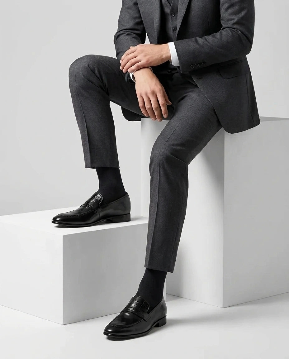 Hudson black leather loafers styled with formal outfit in seated lifestyle shot showcasing comfort, elegance, and premium craftsmanship