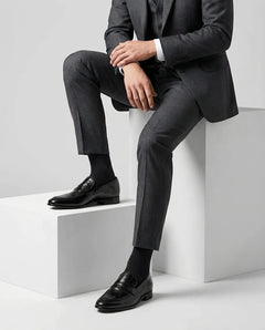 Hudson black leather loafers styled with formal outfit in seated lifestyle shot showcasing comfort, elegance, and premium craftsmanship