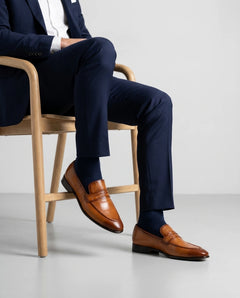 Hudson mustard leather loafers styled with formal outfit in seated editorial pose highlighting comfort, craftsmanship, and premium elegance