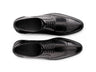 Top angled view of Huxley black lace-up shoes showing lace structure, stitching detail, and premium formal leather craftsmanship