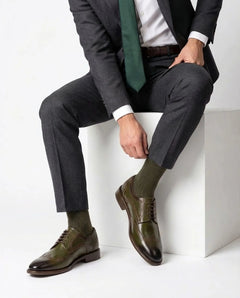 Lanx brogue formal lace-up shoes styled with gery suit in seated model pose highlighting timeless craftsmanship and refined formal style