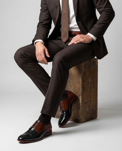 Men’s Ombre lace-up dress shoes styled with formal outfit in seated model pose showcasing modern luxury menswear elegance