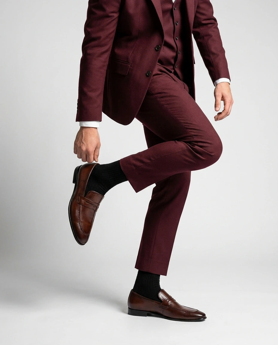 Noble Line Mehrun brown leather loafers styled with maroon suit in a luxury fashion editorial standing pose