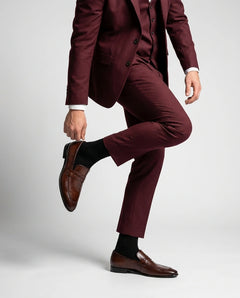 Noble Line Mehrun brown leather loafers styled with maroon suit in a luxury fashion editorial standing pose