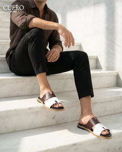 Modern monochrome leather slides photographed in luxury editorial environment