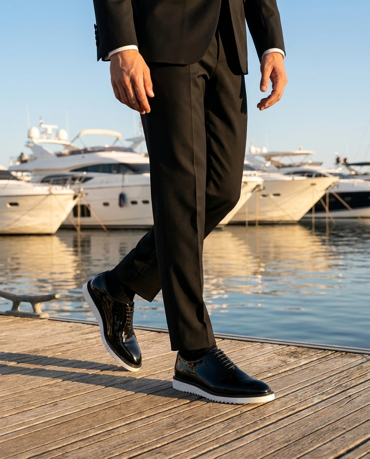 The Vance White black glossy oxford shoes with white sole worn with black suit on yacht dock luxury lifestyle