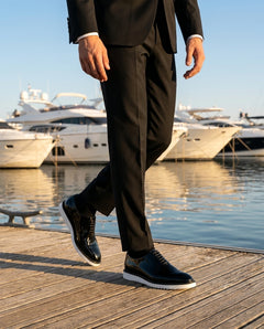 The Vance White black glossy oxford shoes with white sole worn with black suit on yacht dock luxury lifestyle