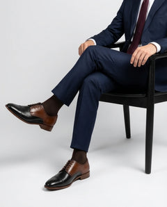 Two-Toned Alfred lace-up shoes styled with formal outfit in seated pose showcasing modern elegance and premium menswear fashion