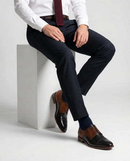Two-Toned Alfred lace-up shoes worn in seated lifestyle pose highlighting comfort, craftsmanship, and refined gentleman aesthetic