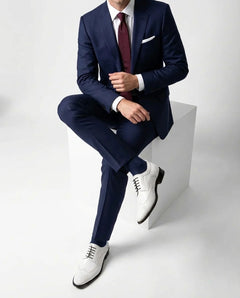 Welby White brogue lace-up shoes worn in seated pose highlighting comfort, craftsmanship, and premium white formal footwear design